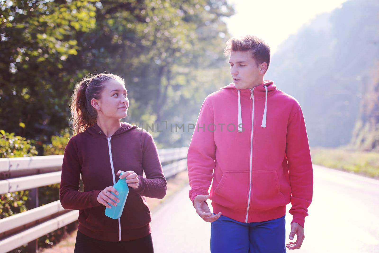 young couple jogging along a country road by dotshock