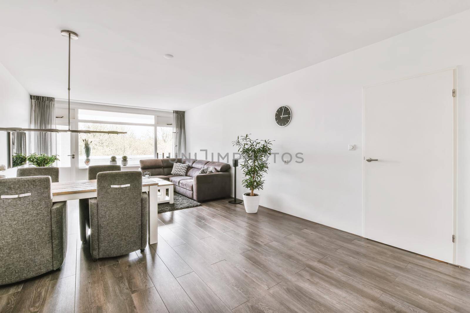 Stylish living room combined with a dining area with upholstered furniture