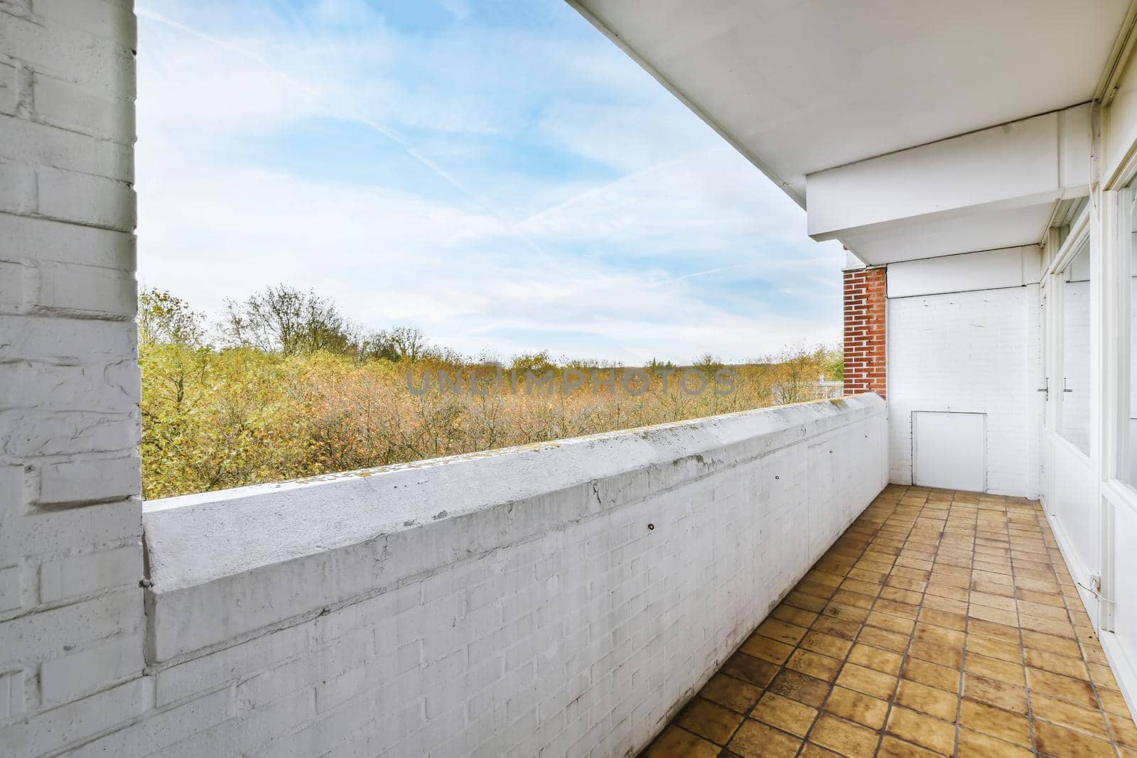 Long narrow balcony with tiled floor and brick handrails