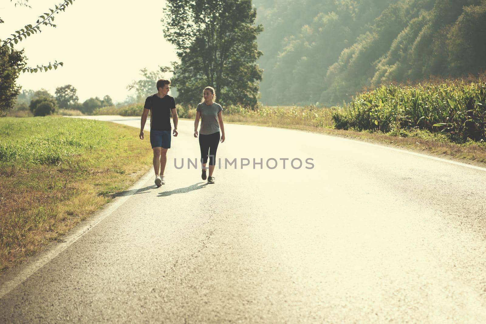 young couple jogging along a country road by dotshock