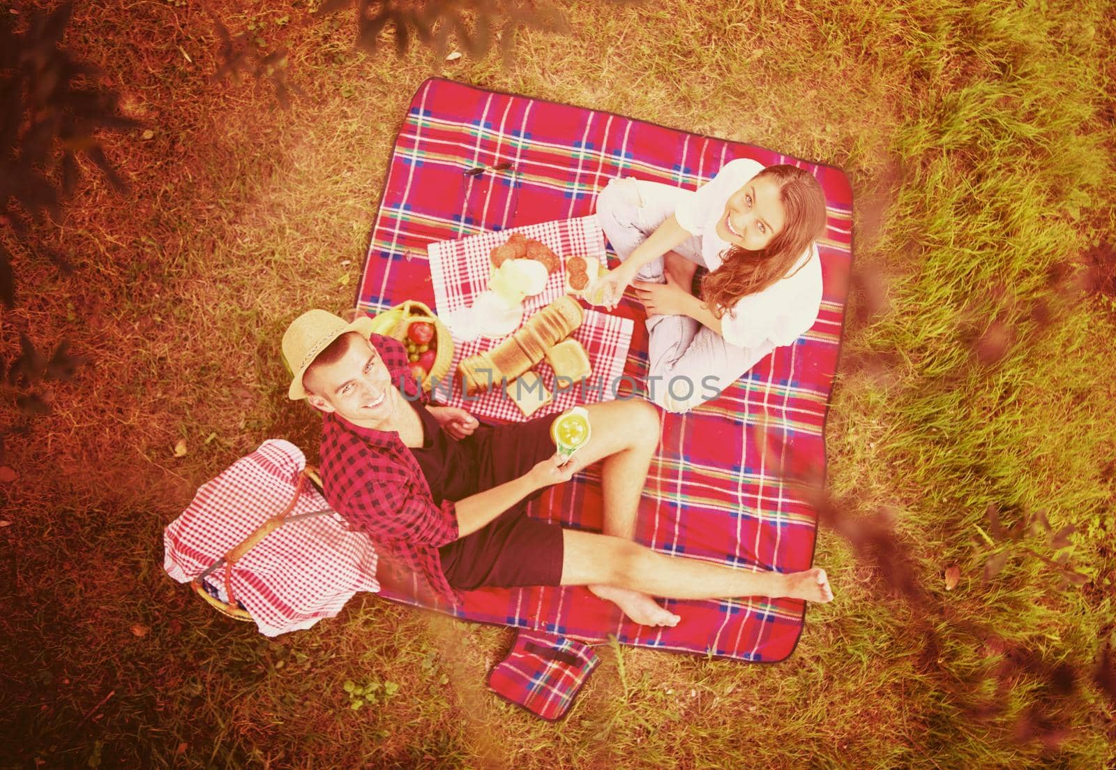 Couple in love enjoying picnic time drink and food in beautiful nature on the river bank top view