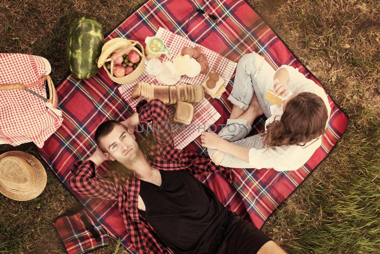 Couple in love enjoying picnic time drink and food in beautiful nature on the river bank top view