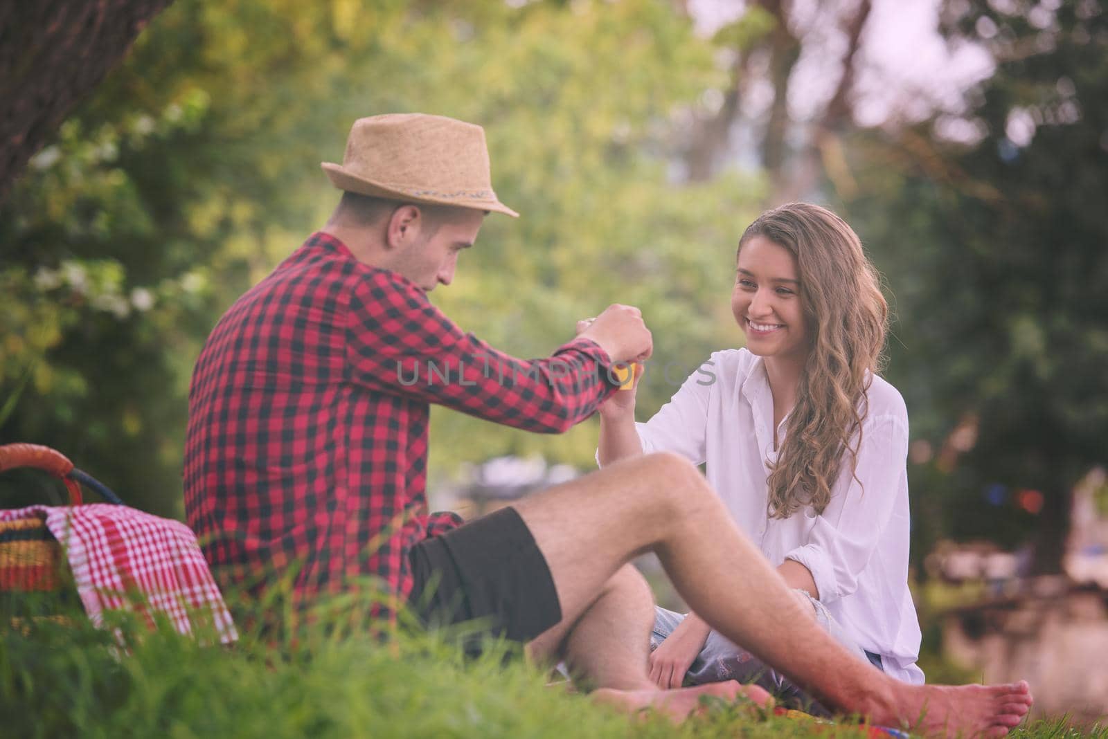 Couple in love enjoying picnic time drink and food in beautiful nature on the river bank