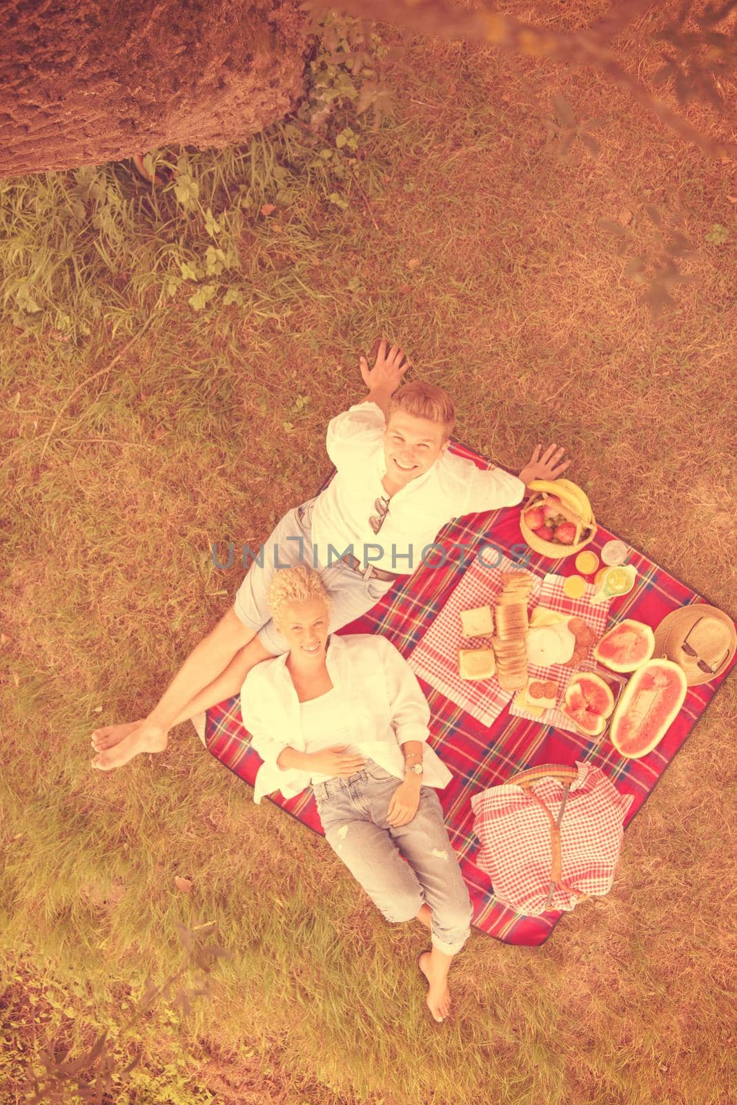 Couple in love enjoying picnic time drink and food in beautiful nature on the river bank top view