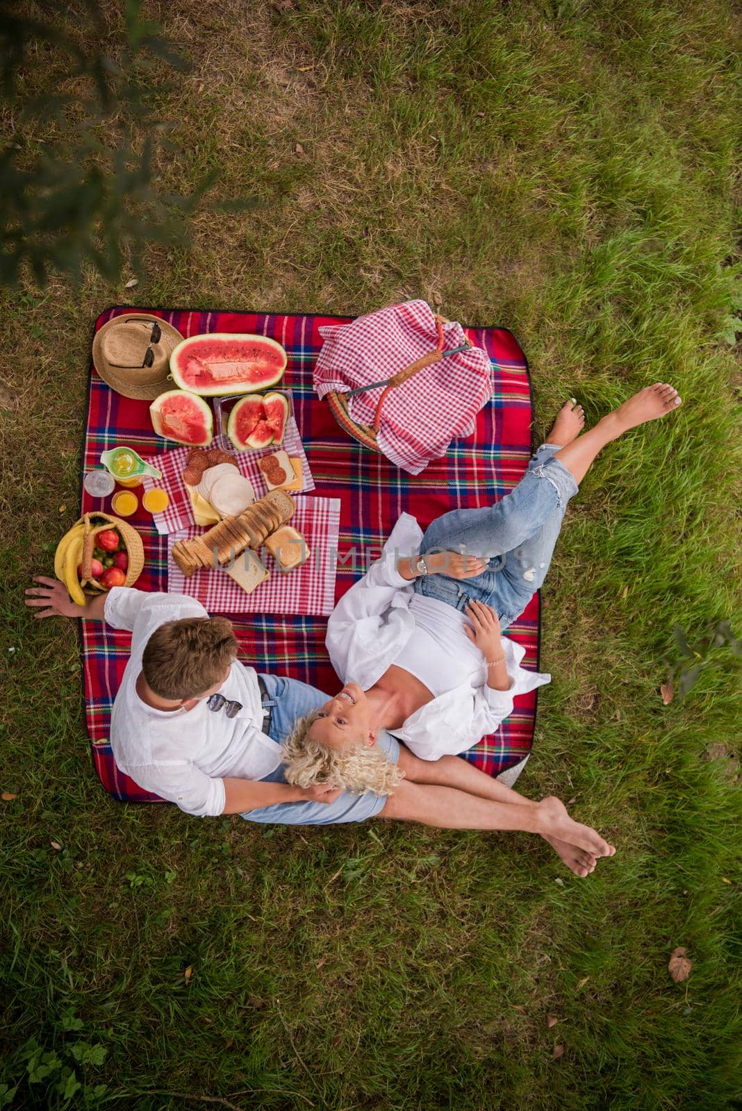 Couple in love enjoying picnic time drink and food in beautiful nature on the river bank top view