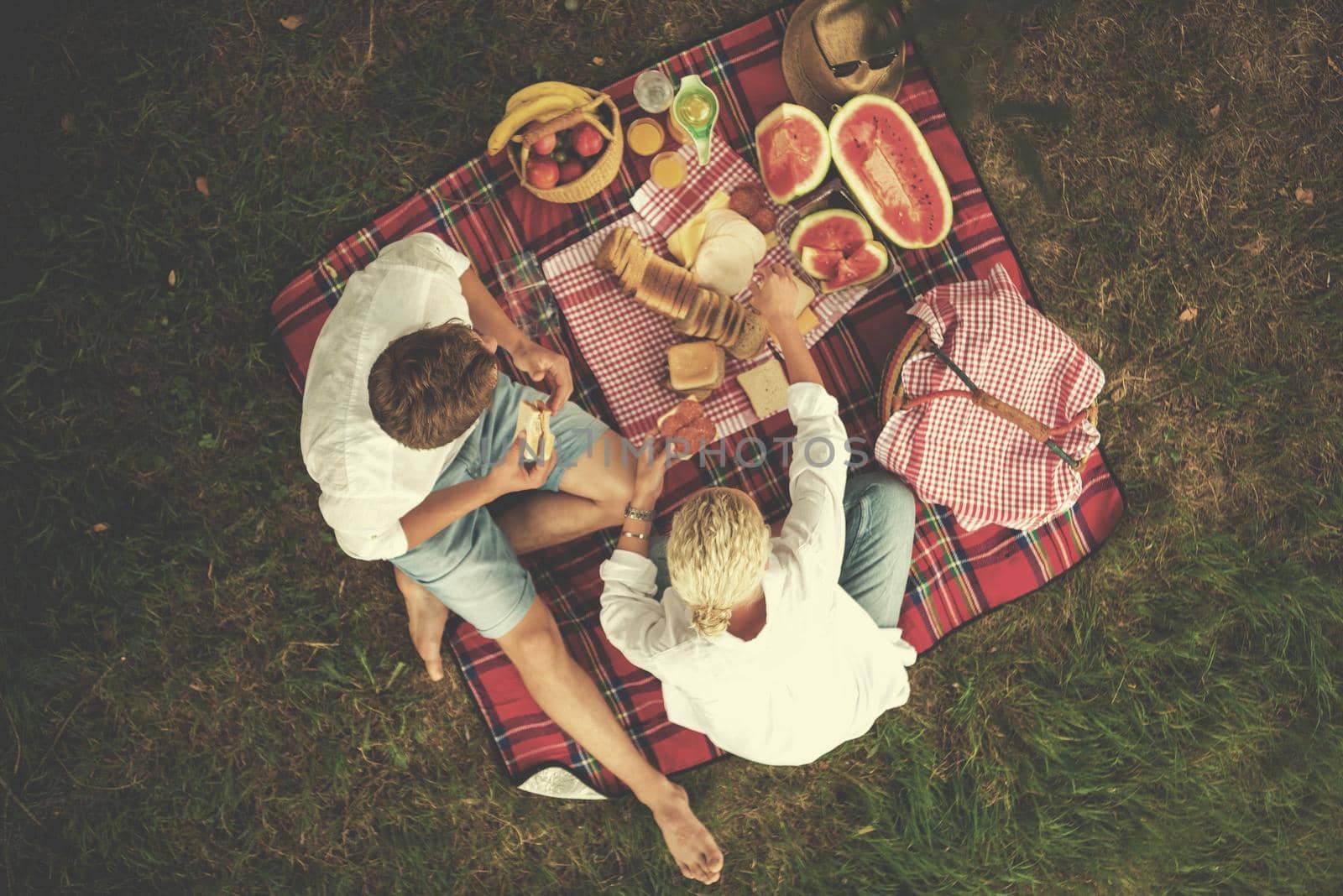 Couple in love enjoying picnic time drink and food in beautiful nature on the river bank top view