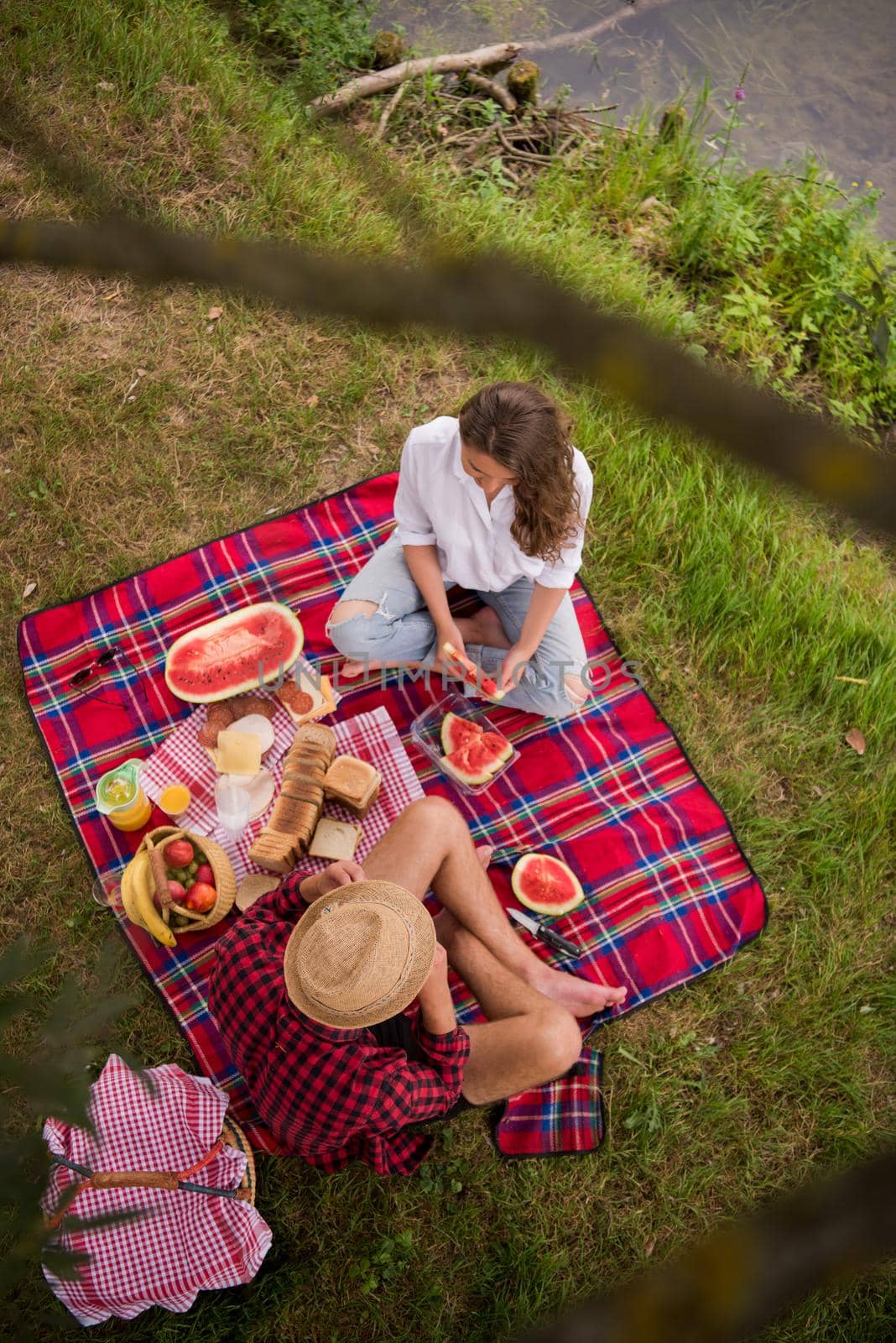 Couple in love enjoying picnic time drink and food in beautiful nature on the river bank top view