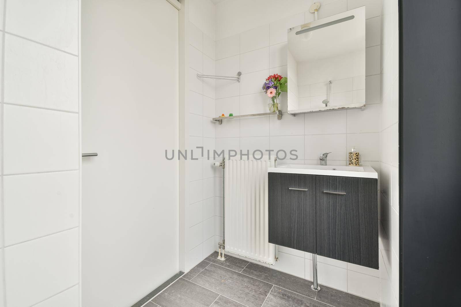 Sink with tap and liquid soap under mirror in contemporary restroom at home