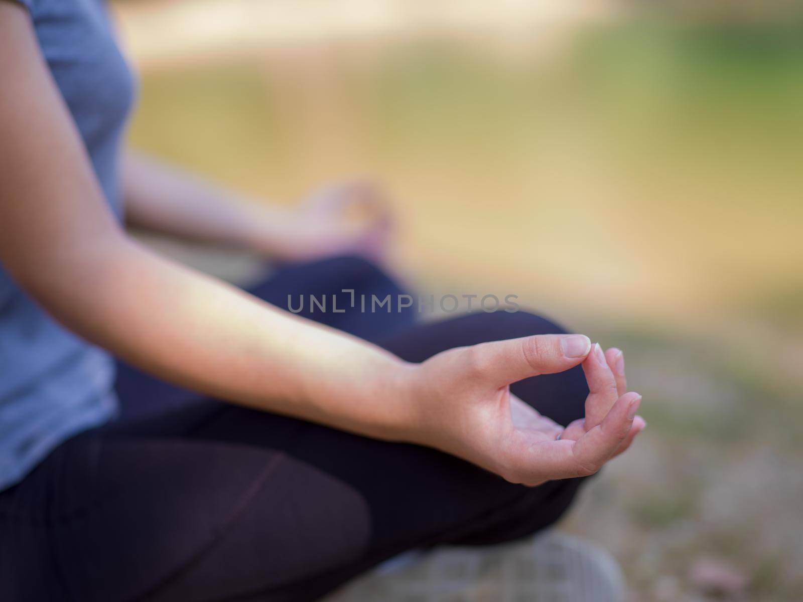 healthy woman relaxing while meditating and doing yoga exercise in the beautiful nature on the bank of the river