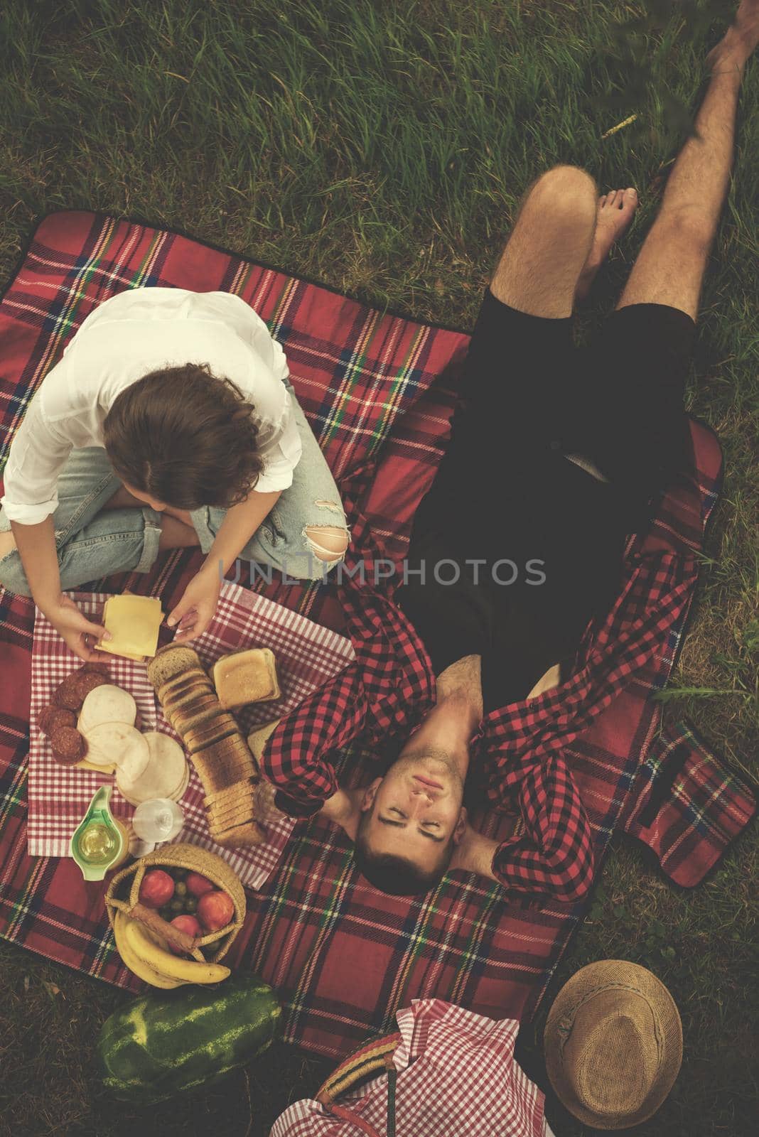 Couple in love enjoying picnic time drink and food in beautiful nature on the river bank top view