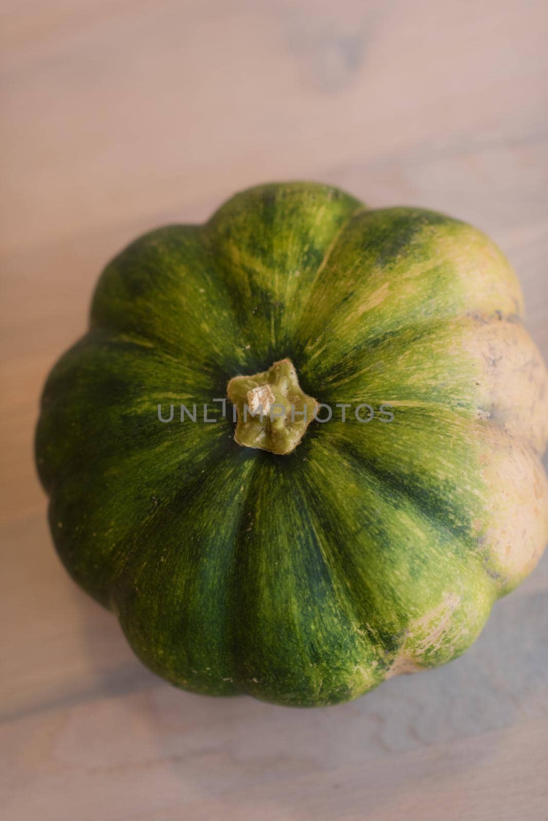 Green pumpkin on a wooden table