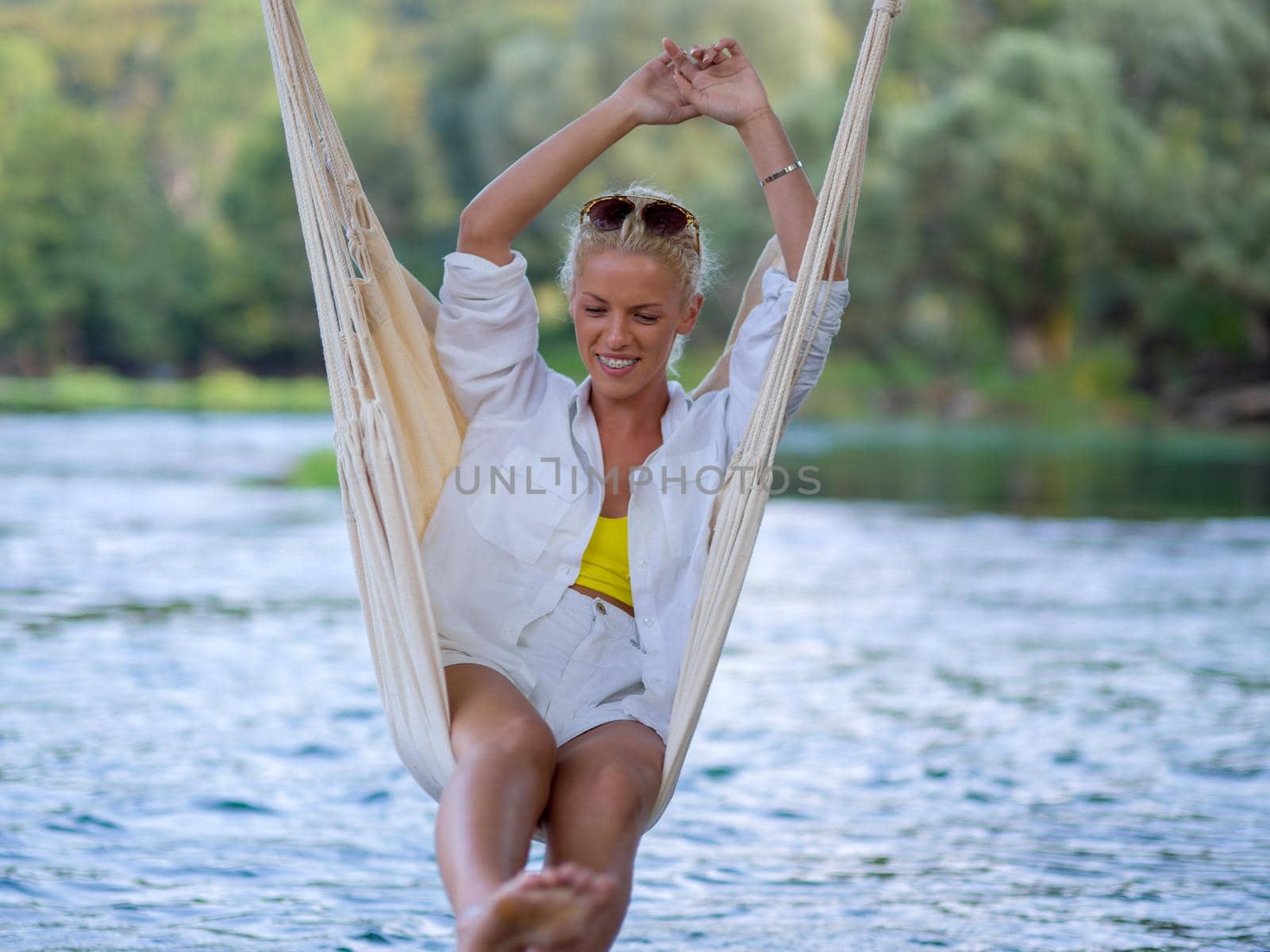 blonde woman resting on hammock by dotshock