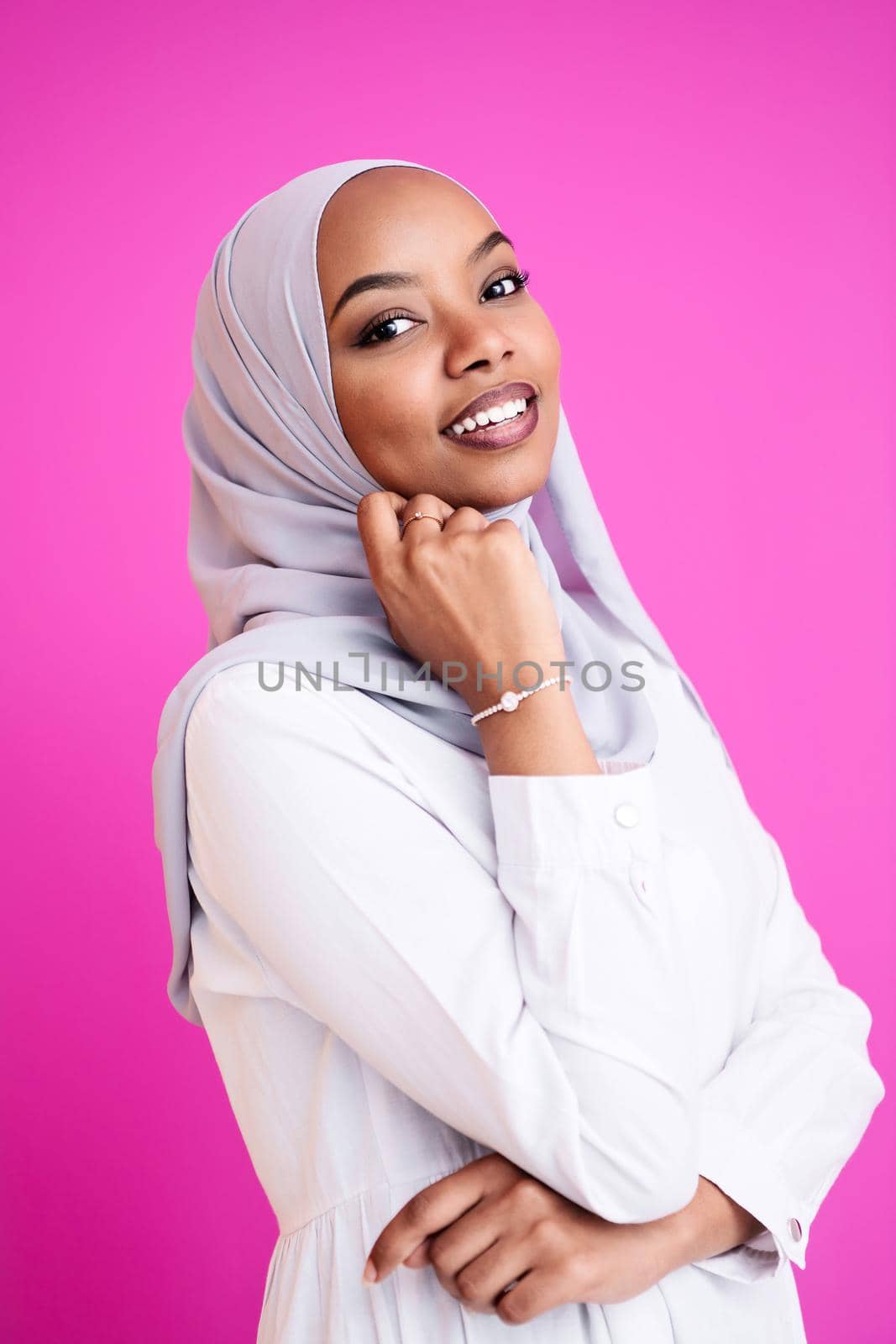 portrait of young modern muslim afro beauty wearing traditional islamic clothes on plastic pink background