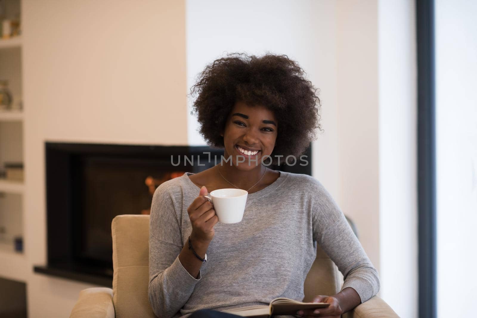 black woman reading book  in front of fireplace by dotshock