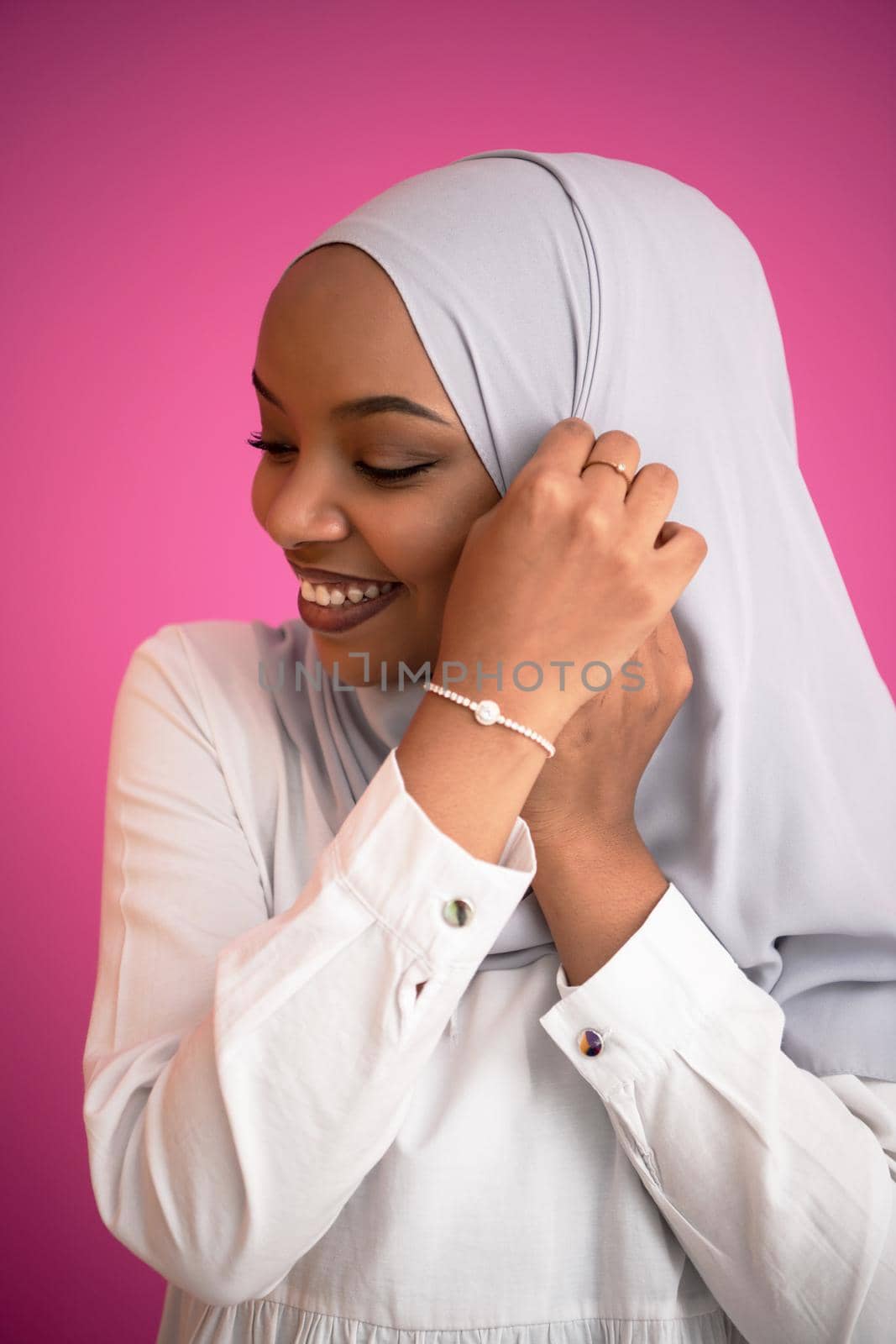 young afro beauty wearing traditional islamic clothes on plastic pink background