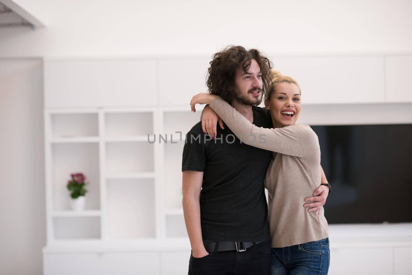 Portrait of a happy young beautiful couple hugging in their new home