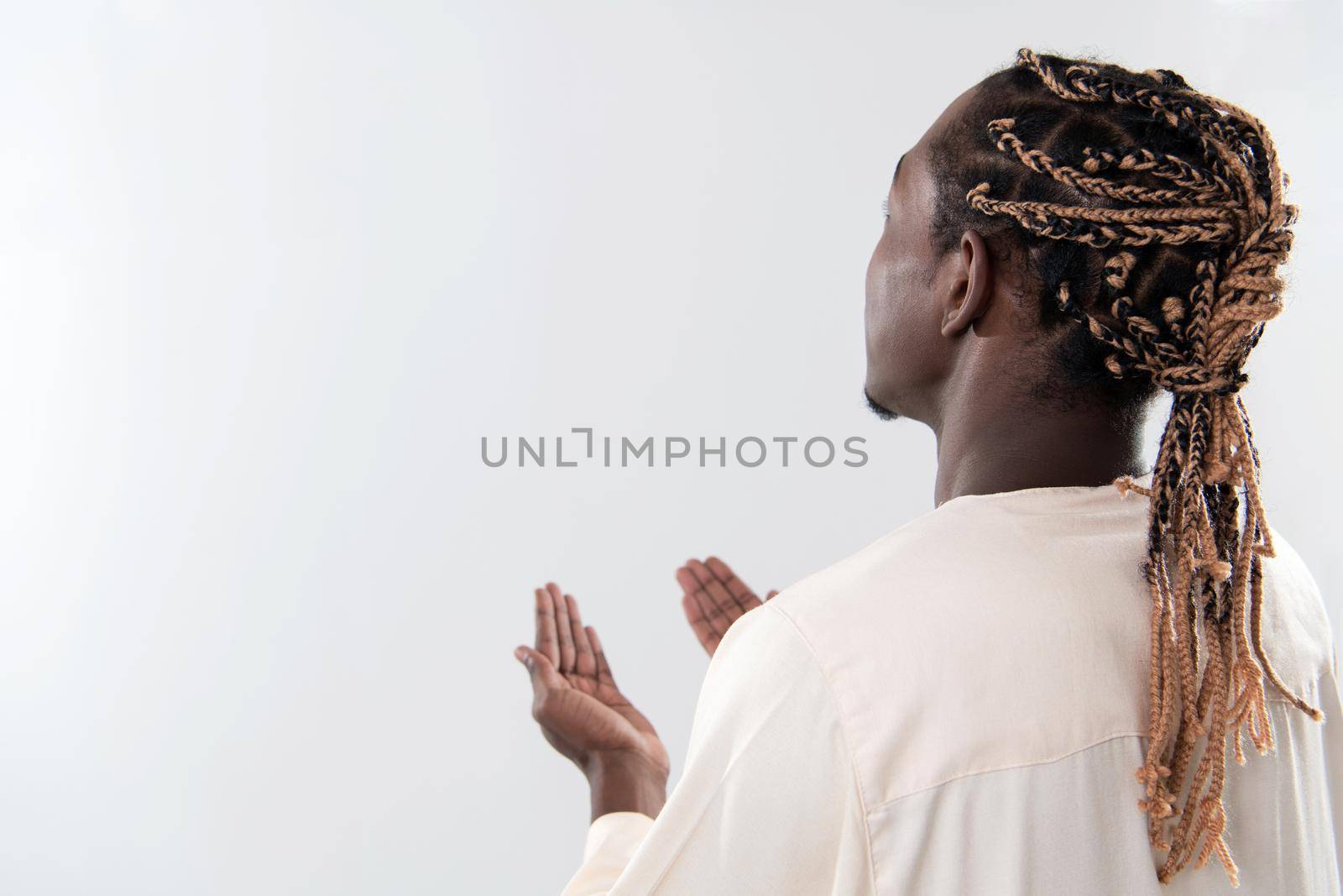 Handsome Young  African Muslim Man Making Traditional Fatiha Prayer To Allah God While Wearing A Traditional Sudan fashion clothes in studio