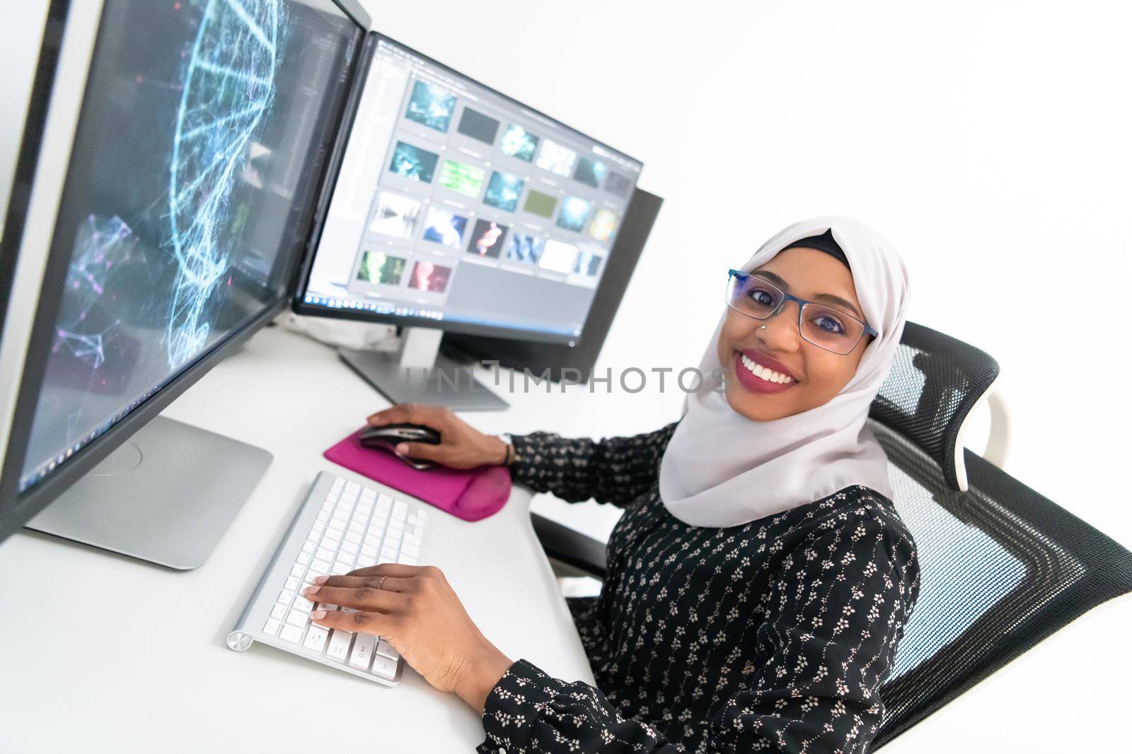 young afro american modern  muslim business woman wearing scarf on creative bright  office workplace with big screen