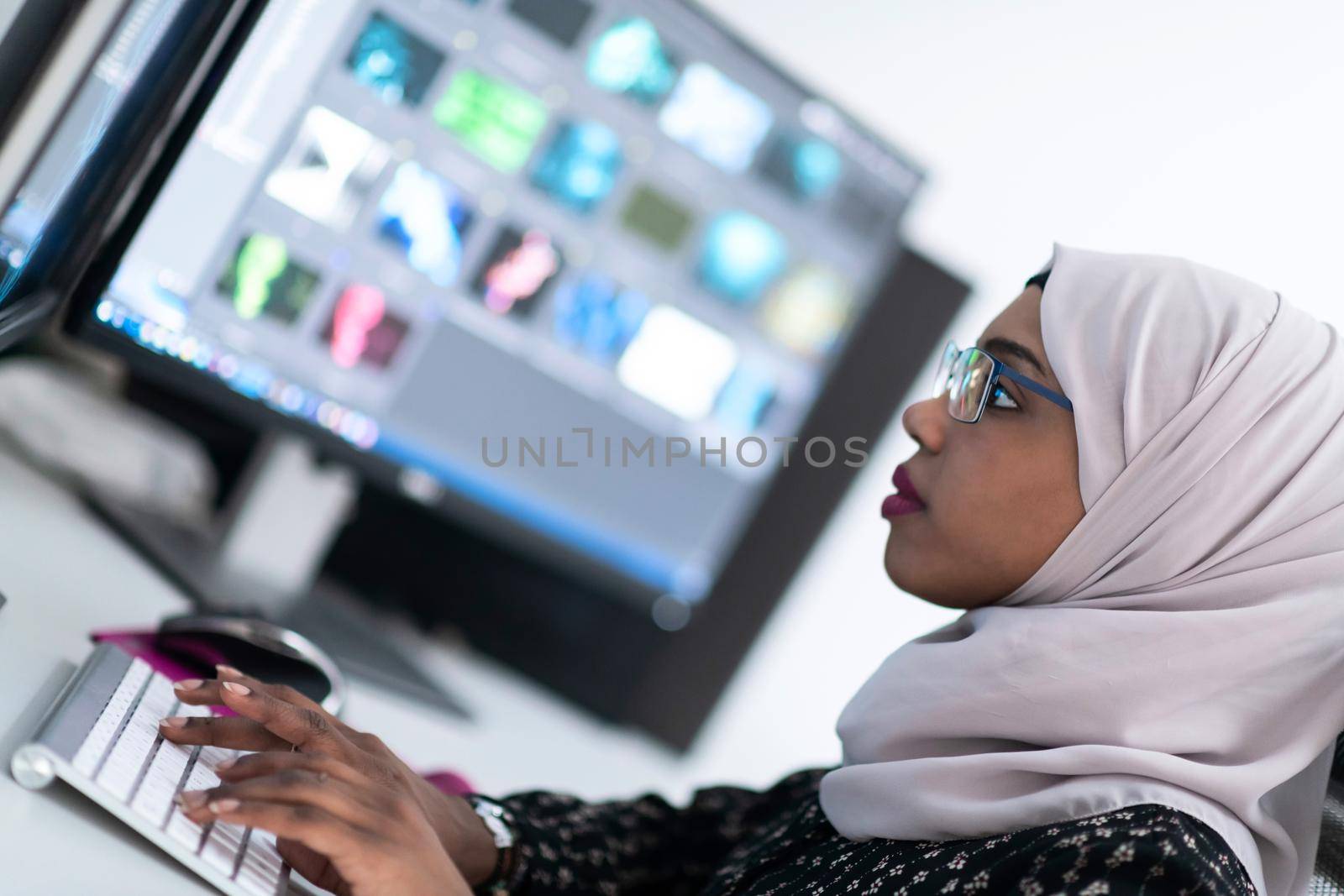 young afro american modern  muslim business woman wearing scarf on creative bright  office workplace with big screen