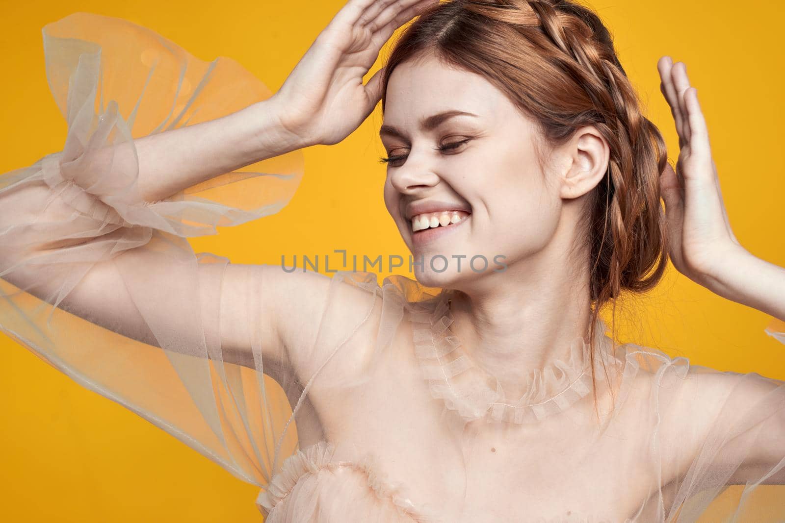 portrait of a woman gesture hands cosmetics fashion hairstyle posing yellow background. High quality photo