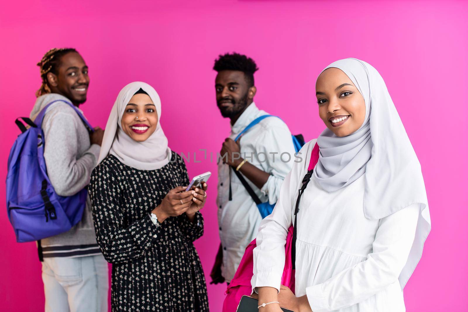 african students group using smart phones with plastic pink background