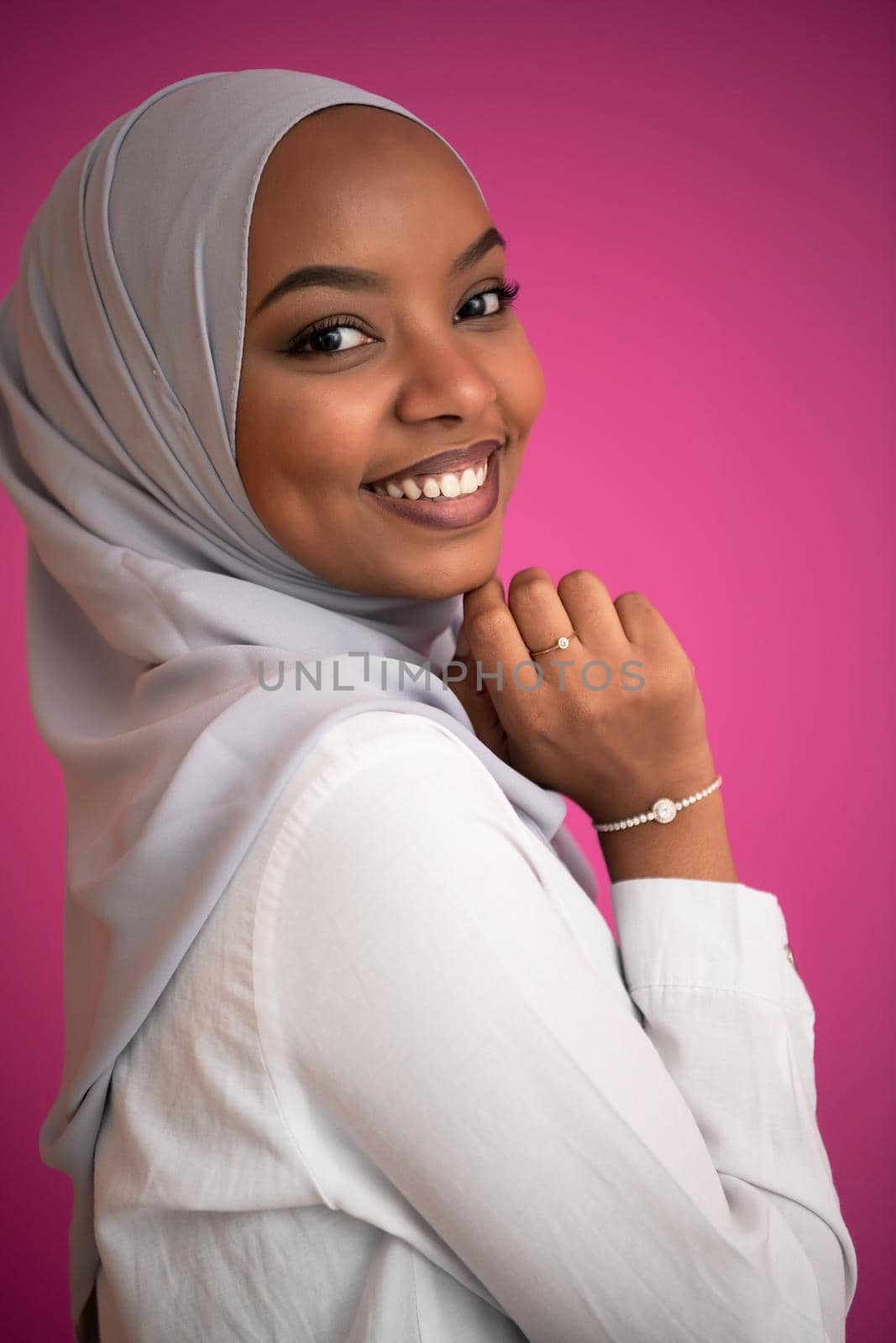 young afro beauty wearing traditional islamic clothes on plastic pink background
