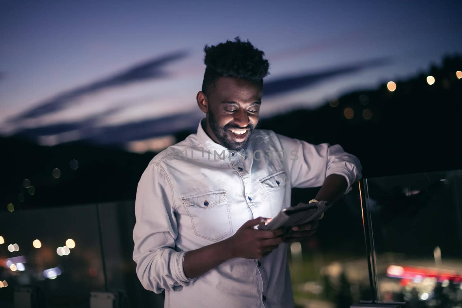 Young  Afro man on  street at night using phone by dotshock