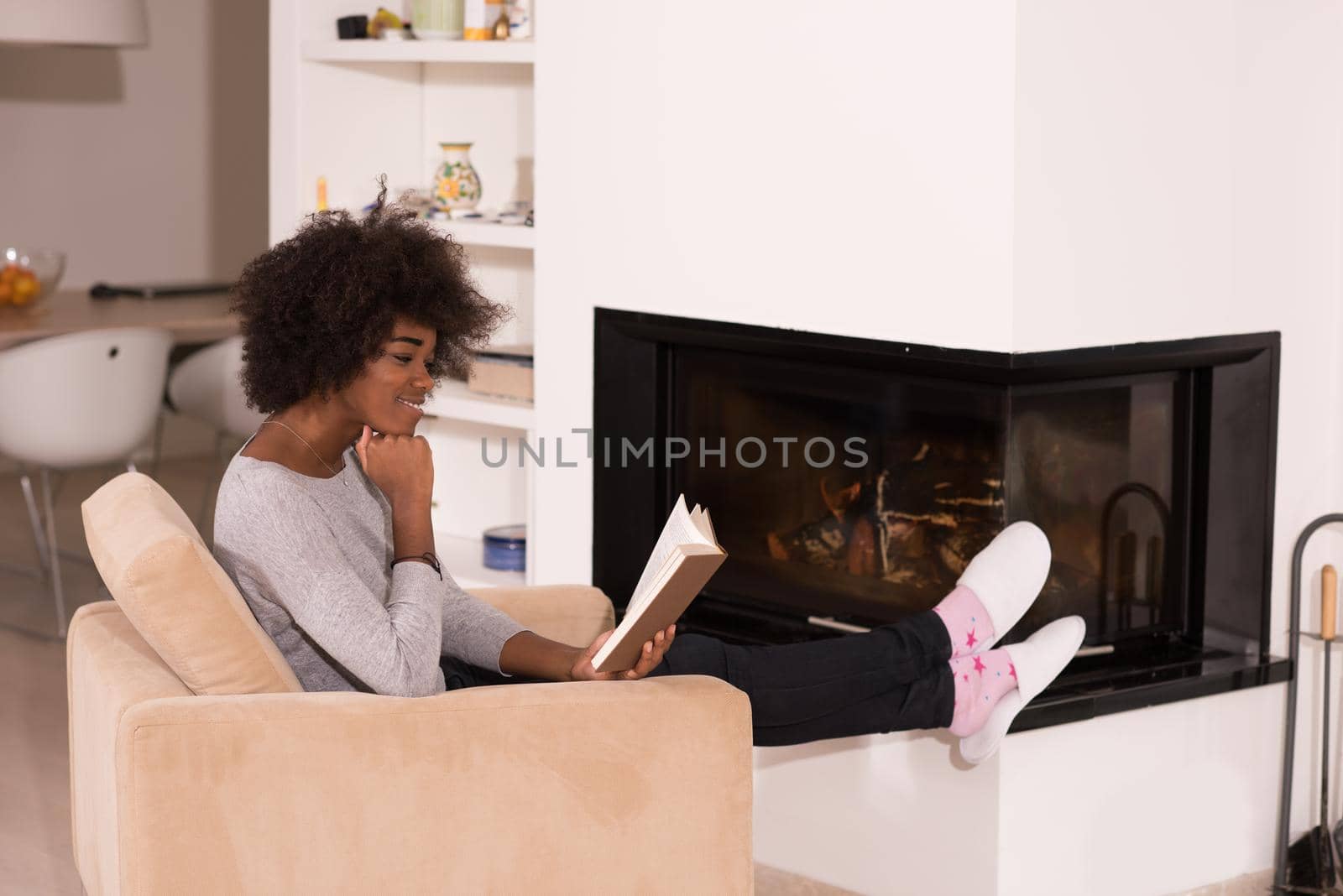 black woman at home reading book by dotshock