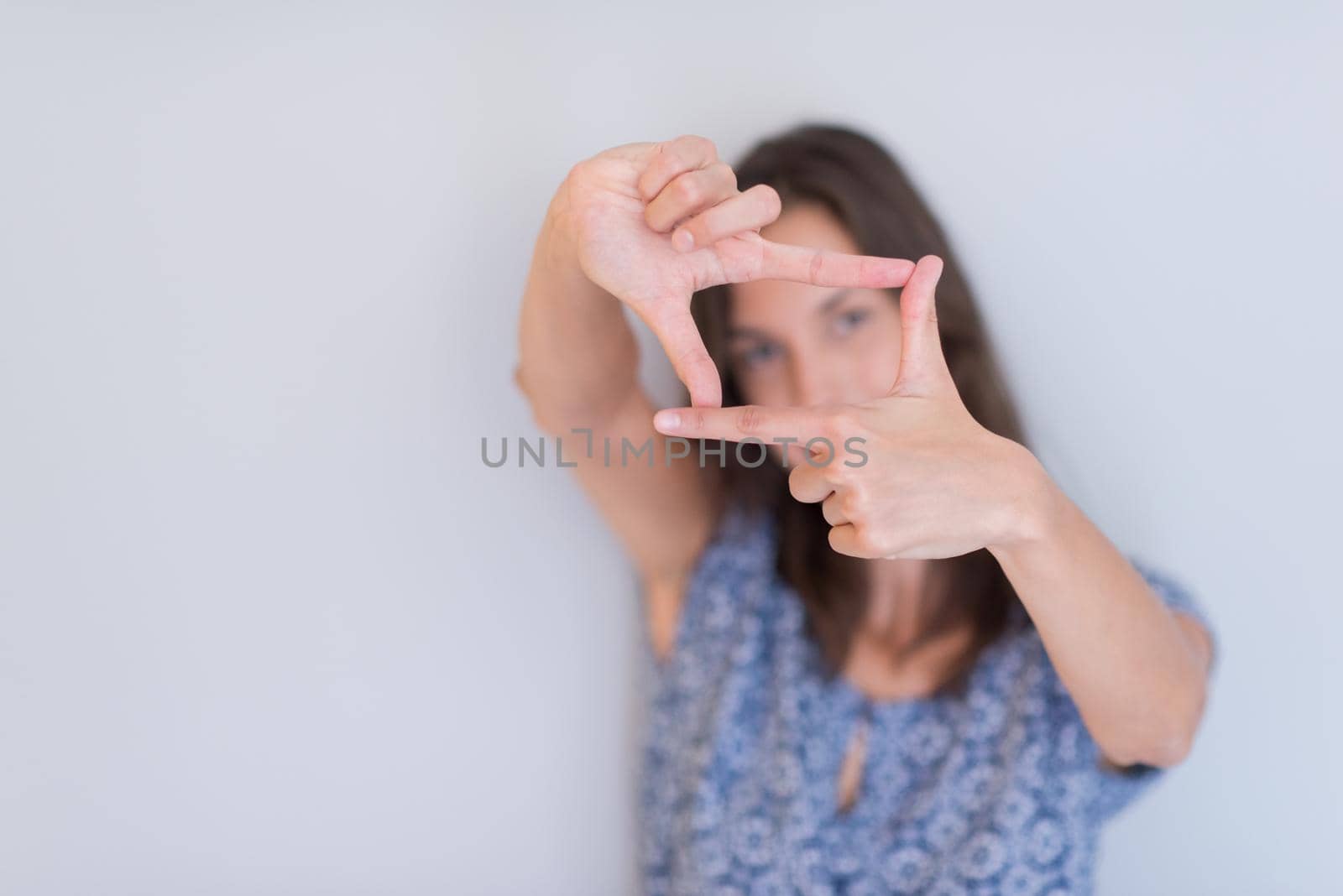 young happy woman showing framing hand gesture isolated on a white background