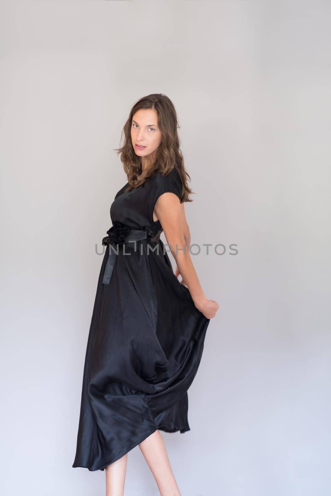 portrait of Beautiful young woman wearing a black dress isolated on white background