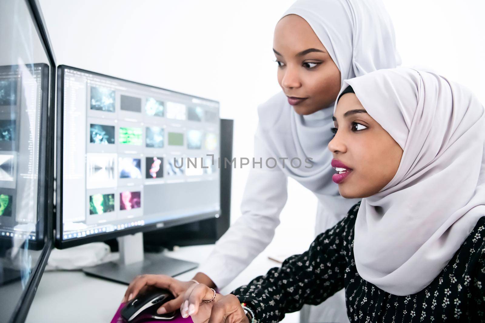 friends at office two young afro american modern muslim business women wearing scarf on creative bright  office workplace with big screen