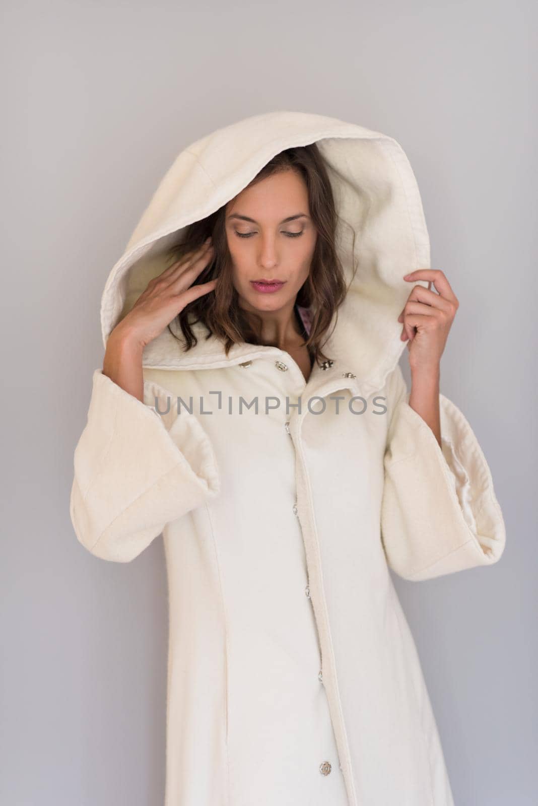 portrait of Beautiful young woman wearing a white coat with hood isolated on white background