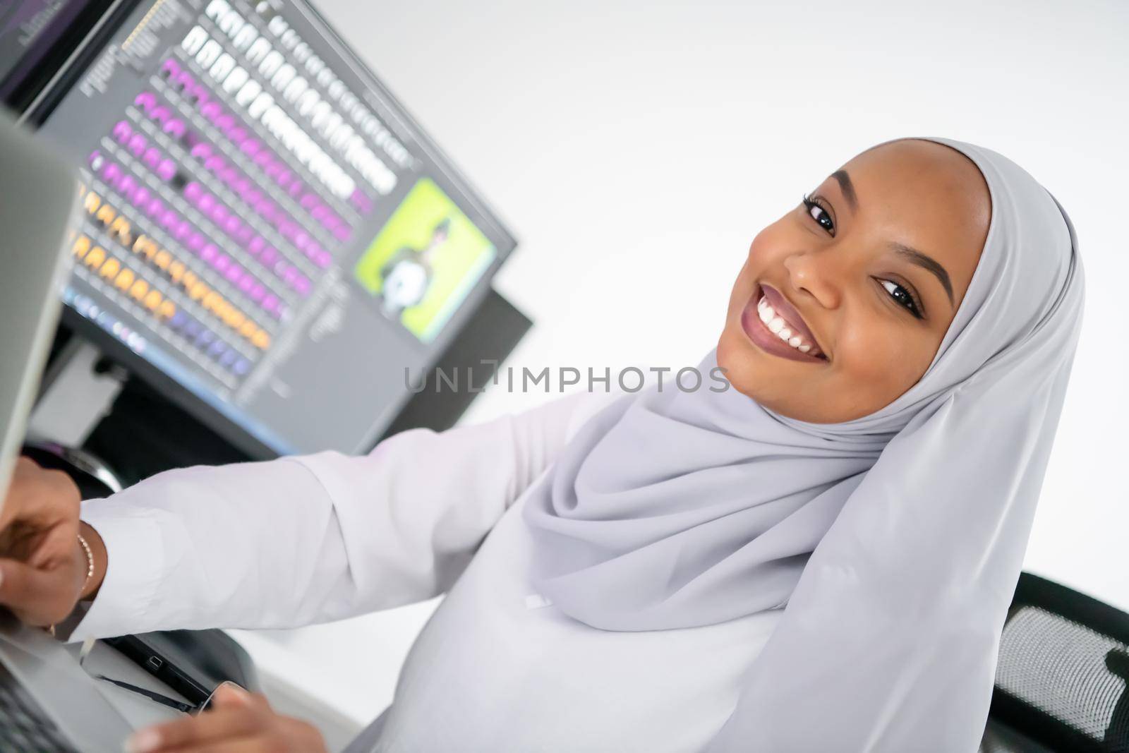 young afro american modern  muslim business woman wearing scarf on creative bright  office workplace with big screen