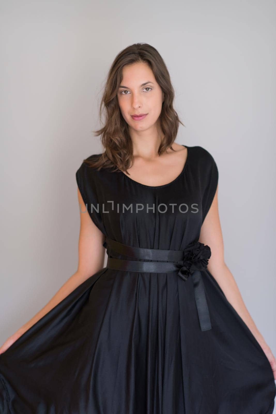 portrait of Beautiful young woman wearing a black dress isolated on white background