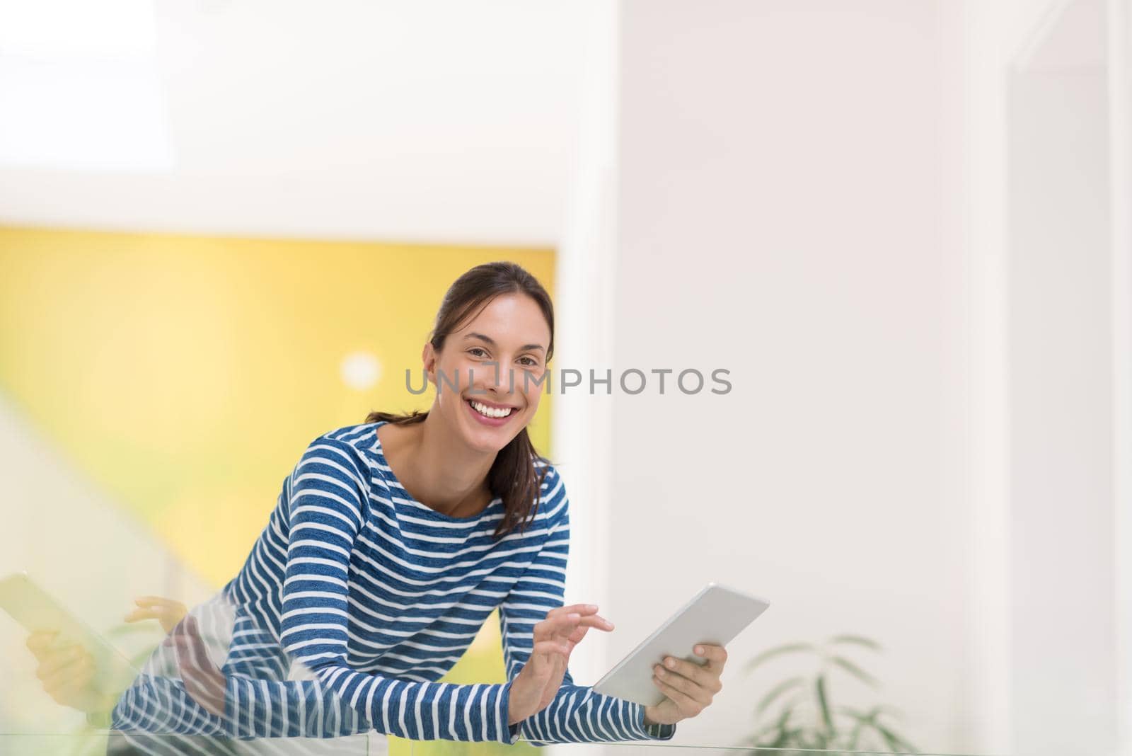 beautiful young woman at home websurfing on internet with tablet