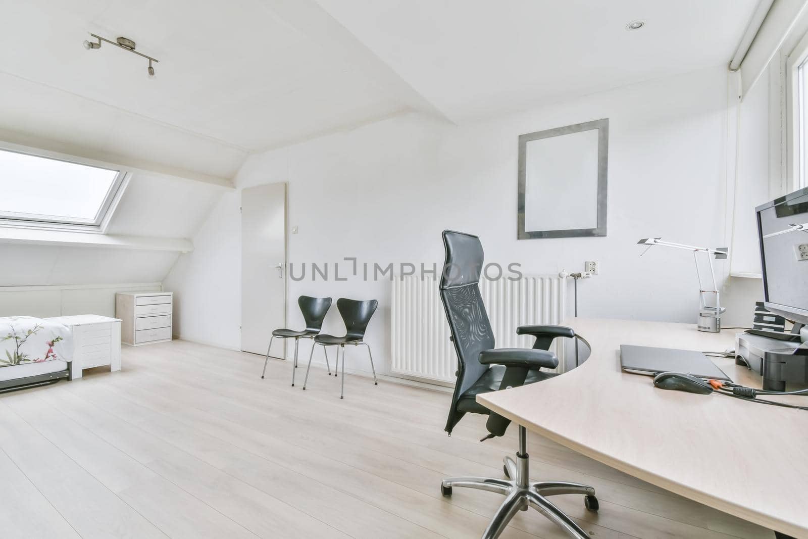 Working area in a large room with a leather comfortable black chair