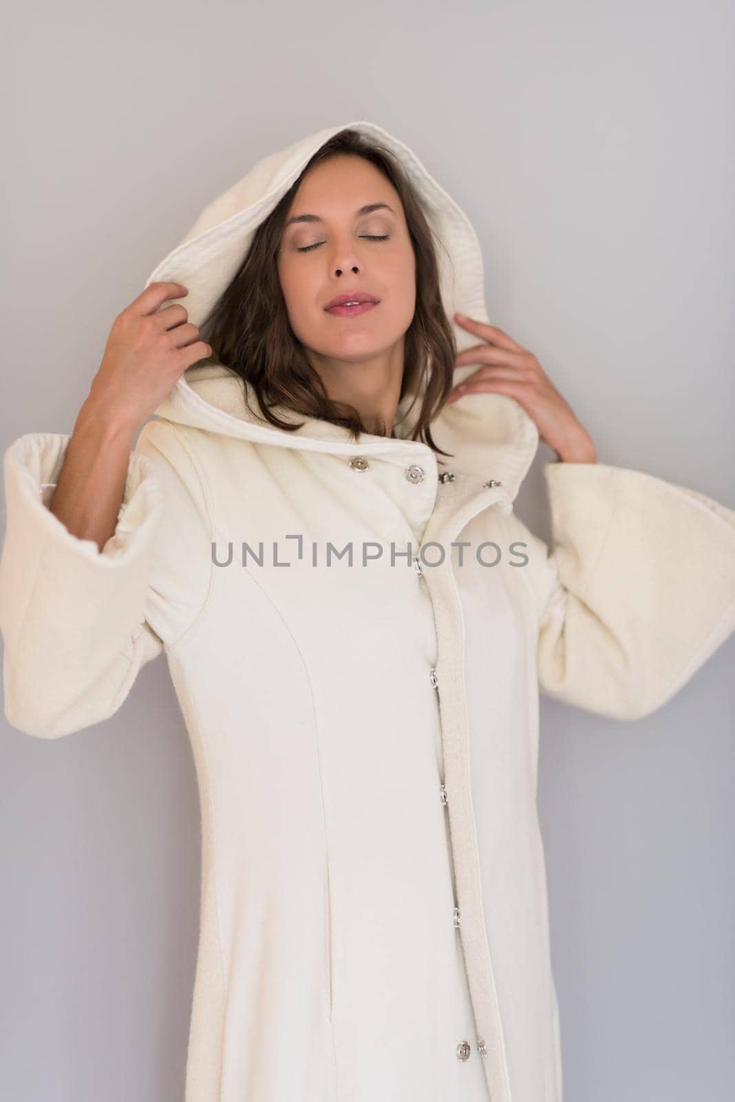 portrait of Beautiful young woman wearing a white coat with hood isolated on white background