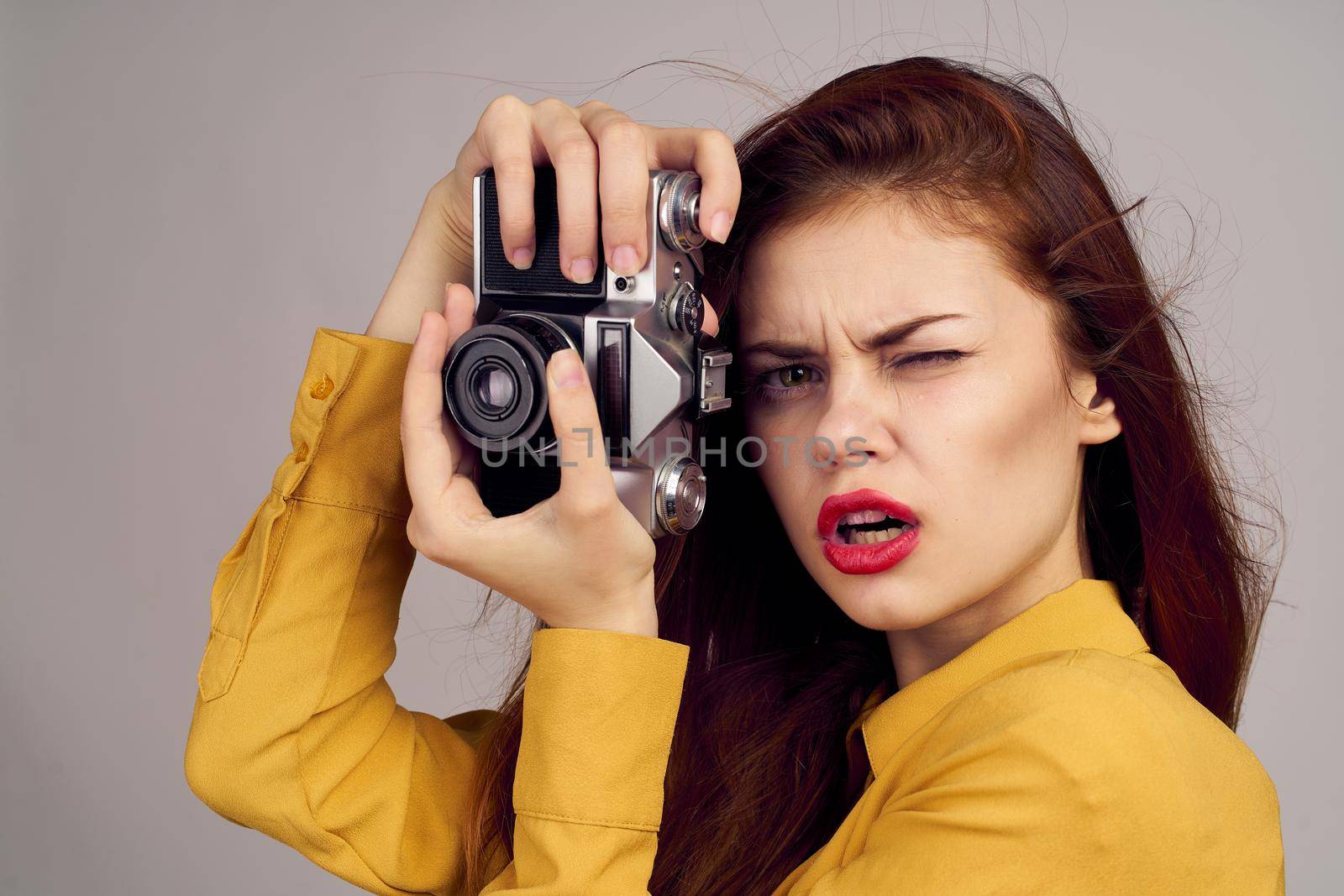pretty woman photographer with camera in yellow shirt on blue background. High quality photo
