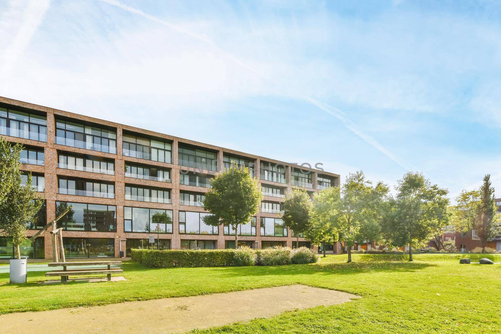 Stunning view of the building with huge windows and a fresh lawn next to the house