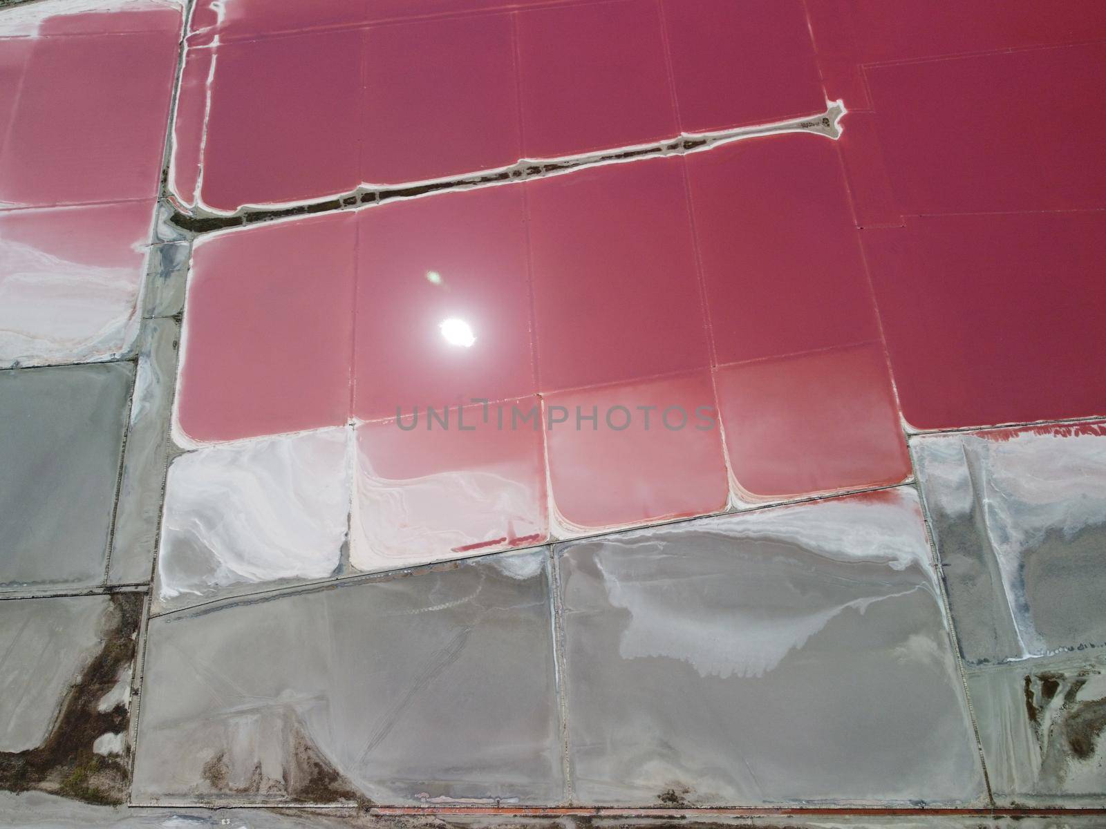 Aerial drone footage of a pink salt lake on a beautiful summer evening. Aerial view of a dried pink salt lake on a beautiful summer evening. Aerial view of a drying out salt lake.