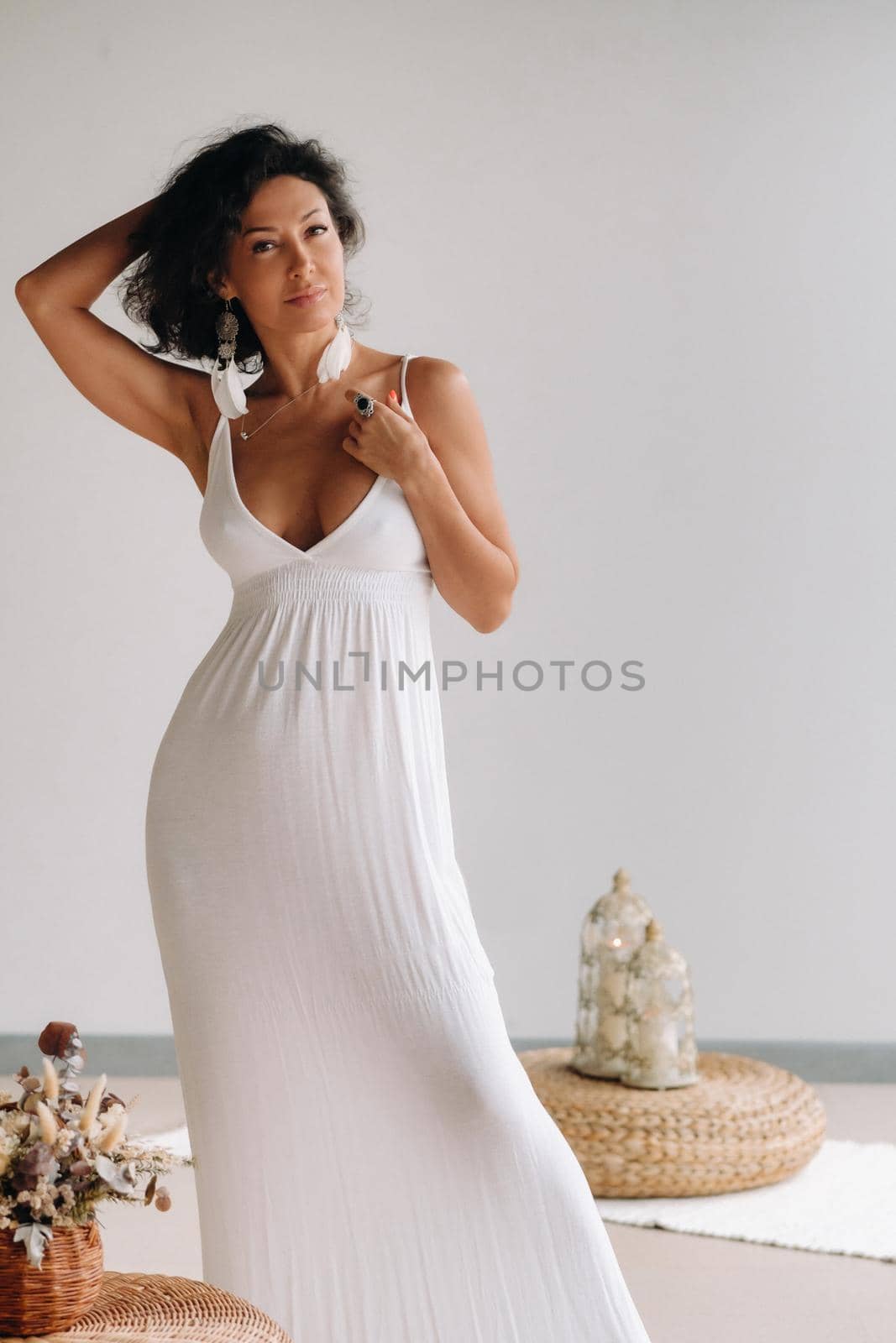 a woman in a white sundress in a bright interior. The concept of relaxation by Lobachad