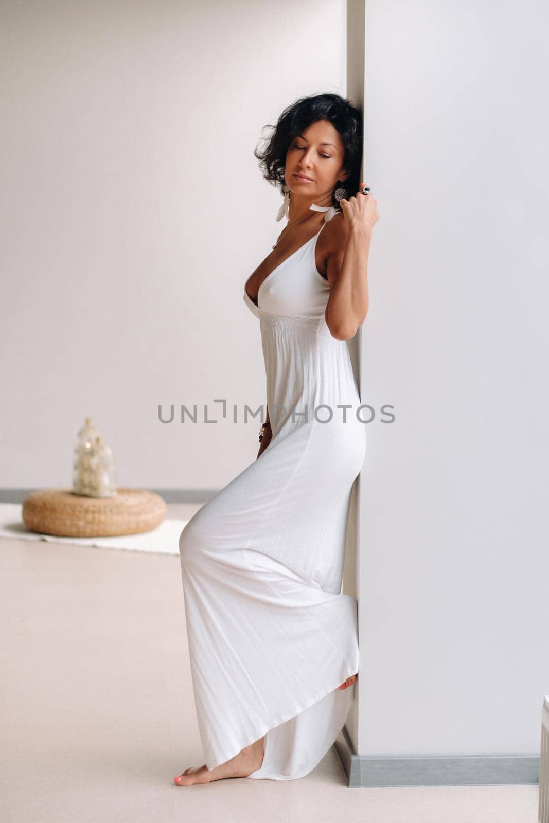 a woman in a white sundress in a bright interior. The concept of relaxation.