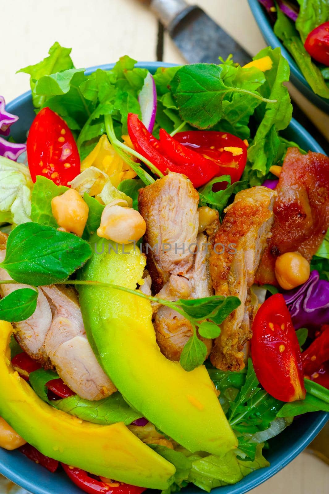 fresh and healthy Chicken Avocado salad over rustic wood table