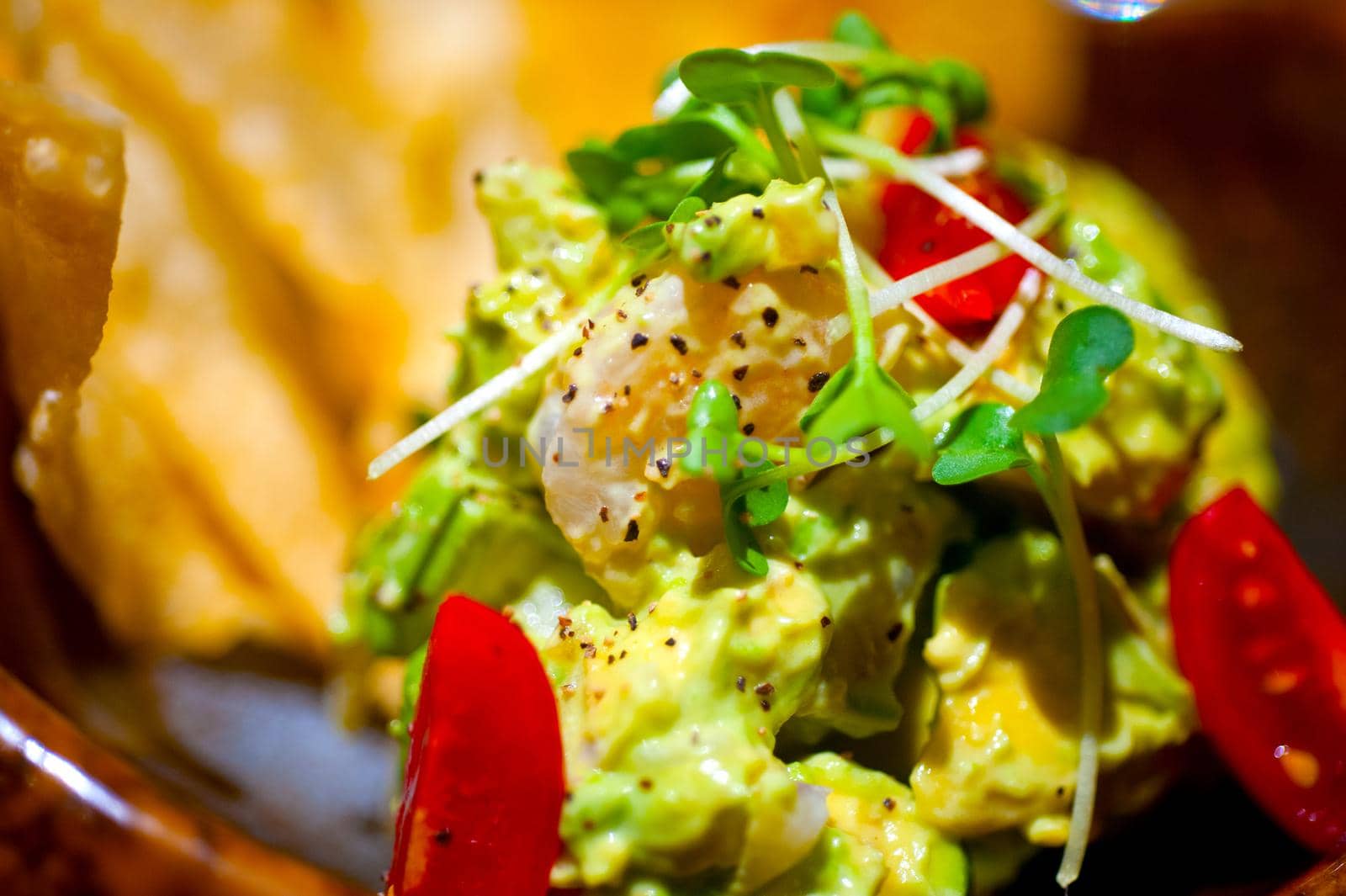 fresh avocado and shrimps salad with nachos on side