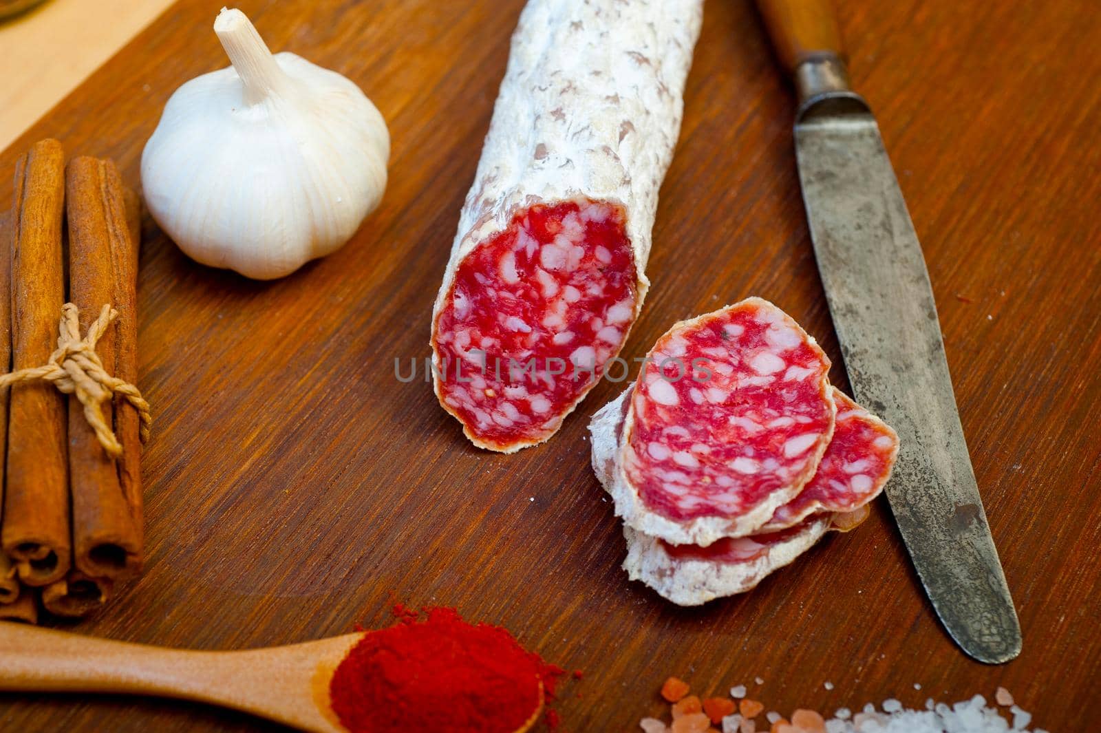 traditional Italian salame cured sausage sliced on a wood board