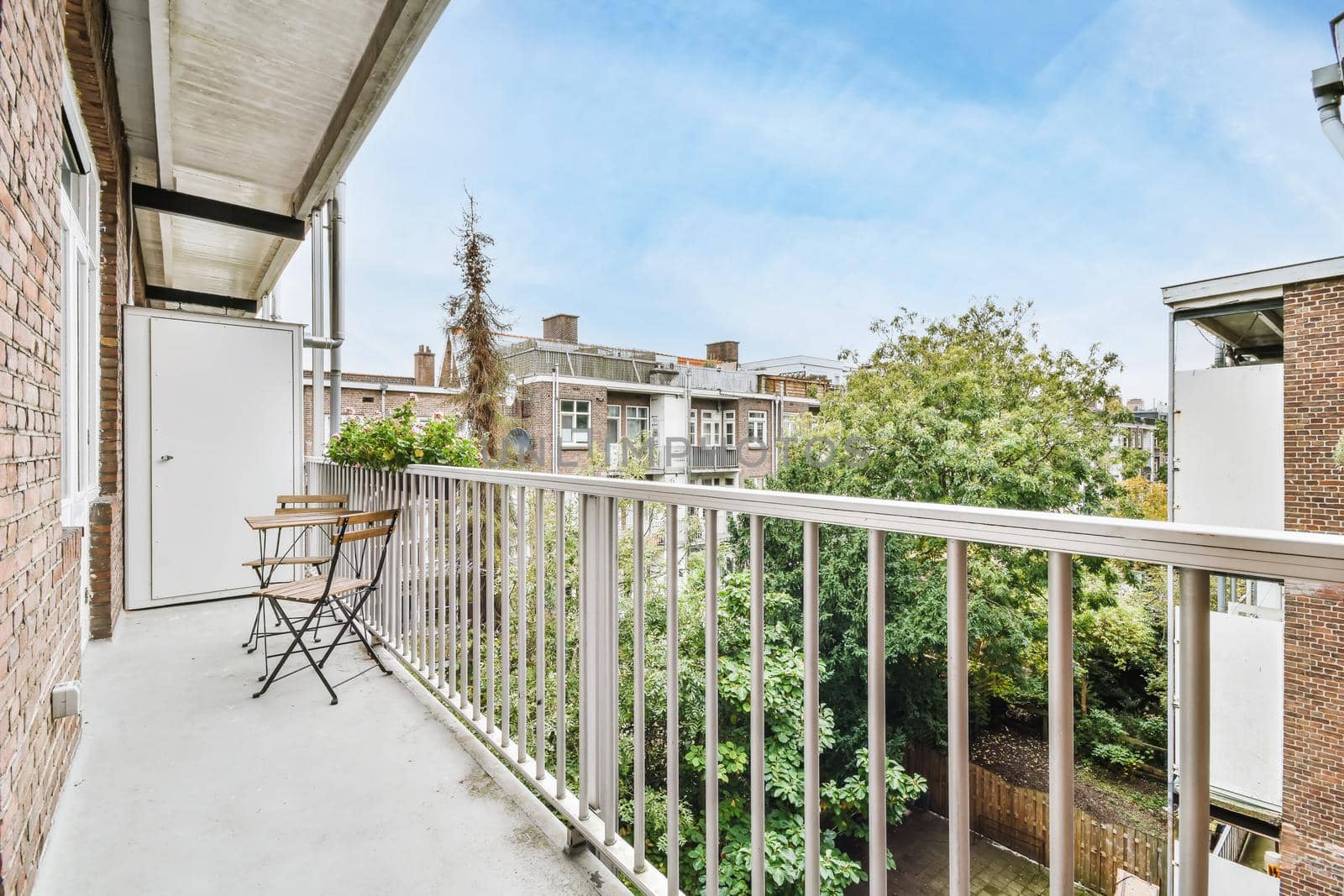 Elegant narrow and long balcony with wooden table and chairs