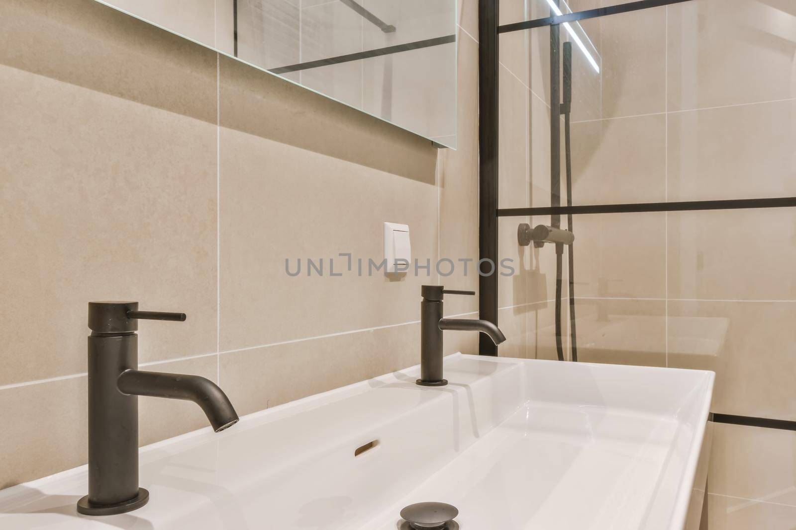 Stylish bathroom in a minimalist style in beige and black tones with a large sink