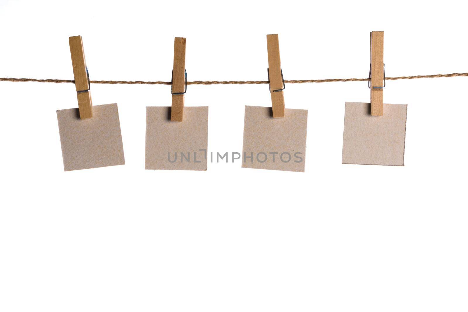 4 Note paper cards hanging with wooden clip or clothespin on rope string peg isolated on white