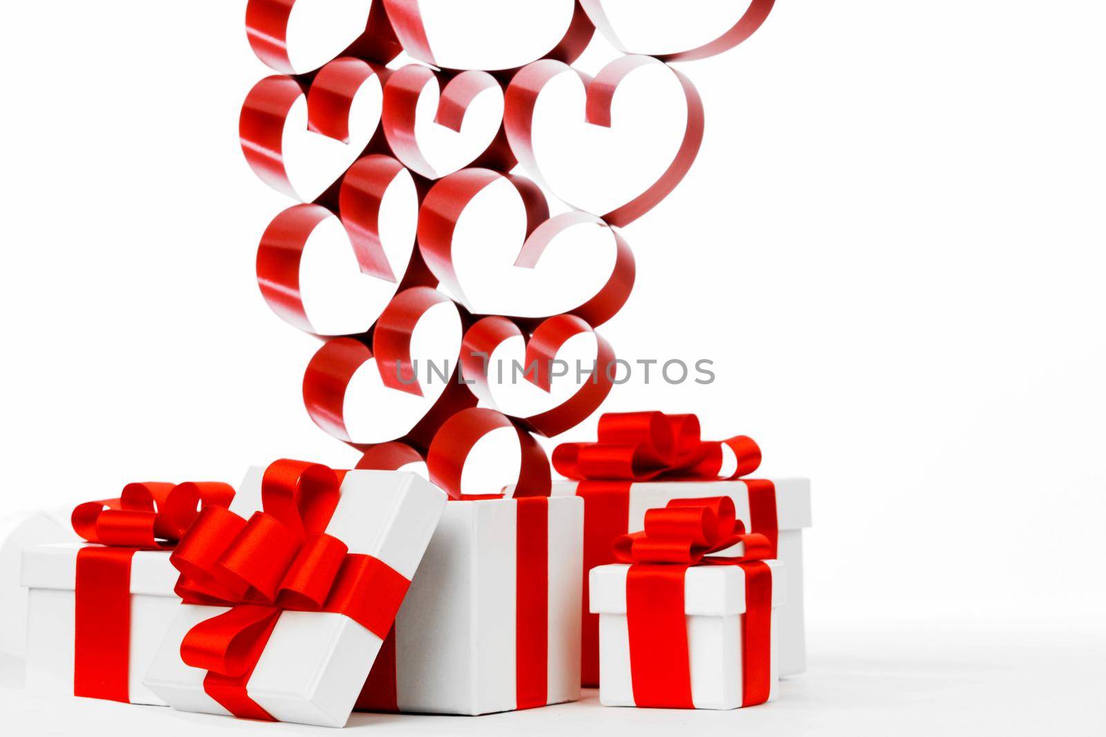 Valentine day gifts in white boxes with red ribbons and hearts isolated on white background