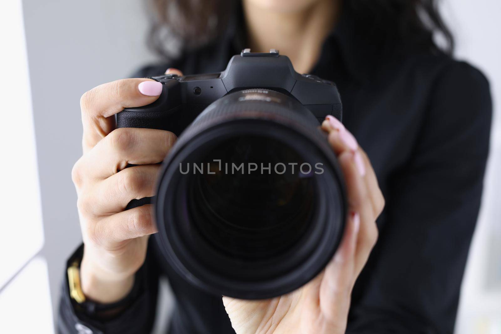 Professional woman photographer hold last model of photocamera by kuprevich
